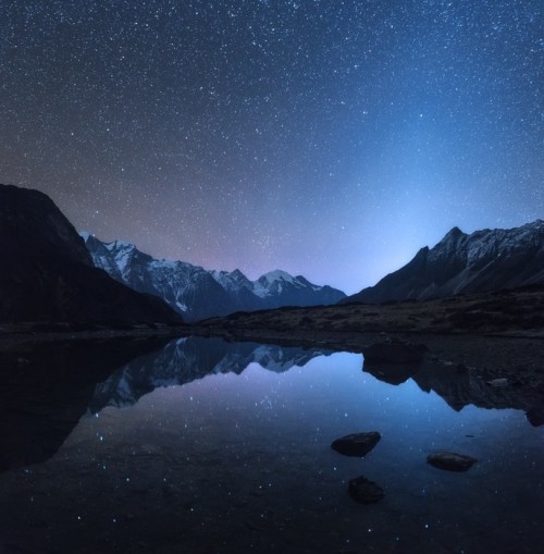 Fototapeta Gwiaździsta noc w Nepalu. niesamowita nocna scena z górami i jeziorem. krajobraz z wysokich skał z ośnieżonych szczyt i niebo z gwiazdami odzwierciedlone w wodzie w Nepalu. podróżować w Himalajach. tło przestrzeni