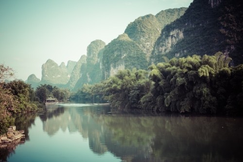 Fototapeta Sceniczny widok yulong rzeka wśród zielonych drewien i krasu gór przy yangshuo okręgiem administracyjnym Guilin, porcelana. yangshuo jest popularnym miejscem turystycznym Azji.